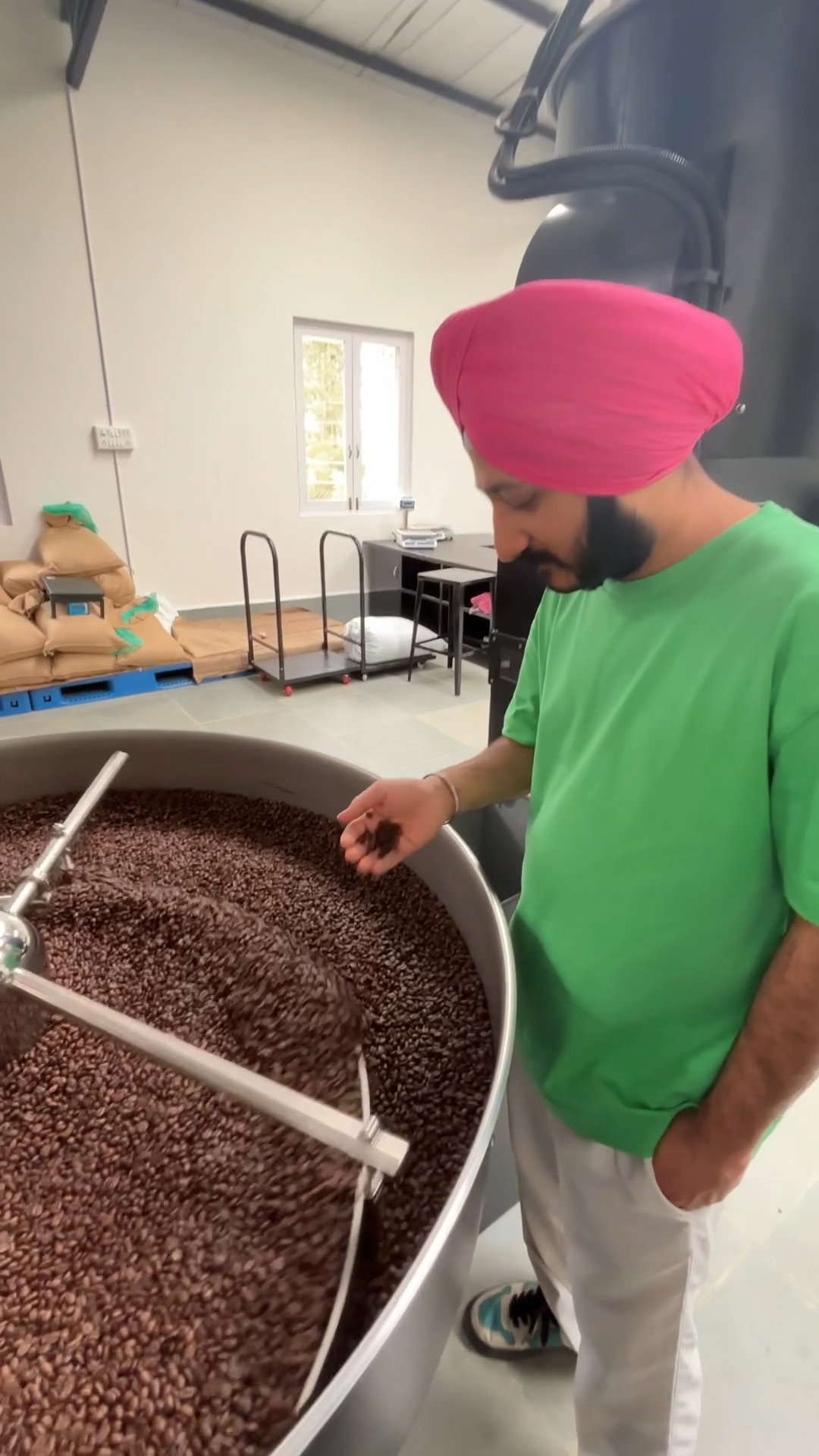 Founder inspecting freshly roasted coffee beans at Theka's roasting facility